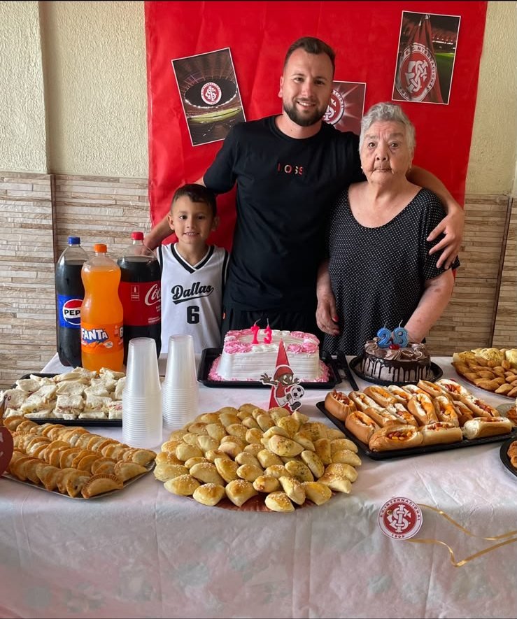 Mesa preparada para a festa, com bolos, salgados e bebidas